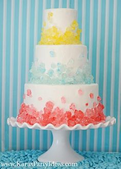 a three tiered cake with gummy bears on the top is white and red