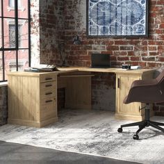 an office desk with a chair in front of it and a brick wall behind it