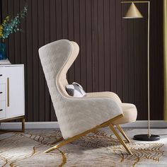 a white chair sitting on top of a rug next to a lamp