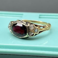 This listing is for garnet ring only ~ Video sows different rings available in our shop which are sold separately . Fabulous antique ~ late Victorian / Art Nouveau~ 14kt solid yellow gold ~ open back faceted deeply colored garnet with three small Old Mine Cut diamonds on each side ~ The sides have leafy design with ornate ring shank . Unmarked but acid tested by professional jeweler for 14kt solid gold . Date: late 19th to early 20th century . Materials: 14K yellow and faceted garnet ( approx si Yellow Gold Garnet Ring With Rose Cut Diamonds, Ruby Ring With Rose Cut Diamonds, Elegant Garnet Ruby Ring Stamped 14k, Fine Jewelry Garnet Rings With Rose Cut Diamonds, Antique Yellow Gold Ruby Ring, Antique Ruby Ring In Yellow Gold, Antique Gold Ruby Ring With Bezel Setting, Gold Rings With Rose Cut Diamonds And Garnet, Heirloom Gold Ruby Ring With Rose Cut Diamonds