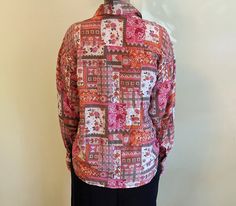 "Gorgeous vintage silk blouse with a beautiful pink & green patchwork design. This soft and flowy silk shirt is fabulous over leggings or tucked into a tight skirt. Button front and cuffs. Size Medium. The model is 5\" 10\" and 135 lbs. 100% Silk. Measures approx. 24\" from armpit to armpit, sleeves measure 22\" long from shoulder seam to cuff, measures 26\" long from top of shoulder to front hem. Excellent condition. No holes or tears." Fitted Pink Patchwork Blouse, Pink Printed Silk Blouse, Silk Pink Floral Print Blouse, Pink Silk Blouse With Floral Print, Pink Patchwork Blouse For Spring, Spring Pink Patchwork Blouse, Pink Long Sleeve Tops With Floral Patchwork, Bohemian Pink Silk Blouse, Pink Silk Bohemian Blouse