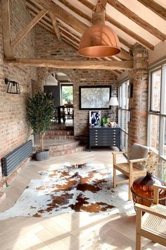 a living room filled with furniture and a cow rug on top of a hard wood floor