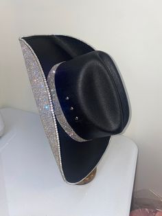 Our black and crystal hat features our square black hat+ crystal rhinestones on the underneath brim. This can easily go with any outfit and can be worn all year long. This hat features: Black square straw hat Crystal rhinestones on the underneath brim Matching crystal hat band Sizing: Our black hats have both sizes S/M and L/XL that features a stretchy hat band We recommend choosing a size S/M if you wear a size 7 1/8 or smaller (which is equivalent to 22 ¼ inches diameter around your head where Evening Hats With Rhinestones And Curved Brim, Silver Hat With Rhinestones For Rodeo, Silver Rhinestone Hat For Rodeo, Black Brimmed Hat With Rhinestones, Rhinestone-embellished Rodeo Hat With Curved Brim, Rodeo Hat With Rhinestones And Curved Brim, Black Wide Brim Hat With Rhinestones, Black Hat With Rhinestones For Evening, Adjustable Black Hat With Rhinestones