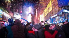 people standing in front of a crowd watching fireworks and confetti being thrown into the air