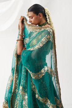 Bright shade of green lehenga with attached cancan and gota patti embroidery. Comes with gold lampi padded blouse and dupatta.
Components: 3
Pattern: Hand Embroidered
Type Of Work: Gota Patti
Neckline: Leaf
Sleeve Type: Sleeveless
Fabric: Lampi
Color: Green
Other Details: 
Floral patterns
Kiran lace hem dupatta
Attached lining
Approx. product weight (in kgs): 6
Length:
Blouse: 13 inches
Lehenga: 44 inches
Occasion: Wedding - Aza Fashions Green Choli With Cutdana For Reception, Green Cutdana Dupatta For Reception, Green Chanderi Lehenga With Cutdana, Pista Green Choli With Gota Work In Traditional Drape, Green Cutdana Lehenga For Wedding, Green Sharara For Reception And Navratri, Pista Green Dupatta With Gota Work For Reception, Pista Green Sharara With Gota Work For Reception, Green Cutdana Sharara For Wedding