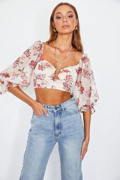 Introducing our Floral Print Chiffon Balloon Sleeved Bustier Crop Top, a chic and stylish addition to your wardrobe. This crop top features a striking floral print that exudes a sense of elegance and charm. The balloon sleeves add a touch of drama and flair to your outfit, making it perfect for both casual and semi-formal occasions. The tied halter neck not only enhances the top's unique look but also provides a customized fit for your comfort. With a back visible zipper, it's easy to put on and take off. Plus, it's fully lined for added comfort and coverage. Style:  Chic  Print / Pattern:  Floral  Silhouette:  Crop Top  Fit:  Fitted  Embellishment:  Tied Halter  Neck Line:  Halter Neck  Sleeve:  3/4 Sleeve  Length:  Cropped  Closure:  Zipper  Lining:  Yes    Made In : China Fabric Content Chic Floral Print Crop Top For Party, Floral Print Crop Top For Brunch, Chic Floral Print Tops For Party, Feminine Chiffon Tops For Vacation, Feminine Chiffon Tops For Brunch, Floral Print Crop Top For Spring Brunch, Chic Floral Print Crop Top For Spring, Chic Cropped Floral Print Crop Top, Floral Print Chiffon Top For Parties