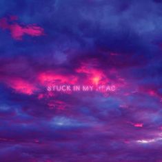 the words stuck in my head are lit up against a purple and blue cloudy sky