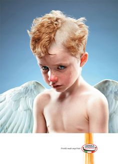 a young boy with an orange pencil sticking out of his mouth and wings on top of him