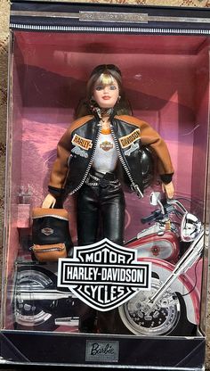 a barbie doll in a box with a harley davidson motorcycle outfit on it's back