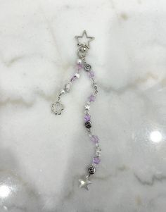 a white marble counter top with a star and beaded necklace hanging from it's side