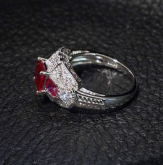 A stunning art deco ruby and diamond replica ring set with cubic zirconia gemstones in platinum overlay sterling silver. US size 7. Only your jeweler will know this is not a fabulous antique art deco ruby ring. *Fine jewelry authenticated by a GIA Gemologist *FREE SHIPPING in USA with signature required for your protection * RETURNS: Contact me for instructions within 7 days - PLEASE NOTE: Returns cannot be accepted on items which have been altered or resized. NO RETURNS ON ITEMS WHERE THE SHOP Red Brilliant Cut Cubic Zirconia Rings, Fine Jewelry Ruby Ring With Diamond For Party, Party Fine Jewelry Ruby Ring With Diamond, Elegant Ruby Ring With Diamond For Party, Dazzling Red Ruby Ring With Diamond Accents, Red Ruby Ring With Diamond Accents, Elegant Lab-created Ruby Diamond Ring With Accent Stones, Elegant Red Cubic Zirconia Rings, Exquisite Red Cubic Zirconia Rings