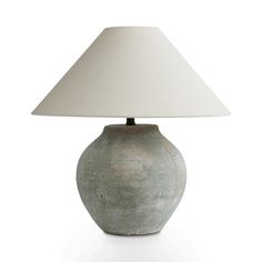 a gray vase with a white shade on it's side and a light in the middle