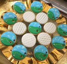 decorated cookies in the shape of golf balls on a gold platter