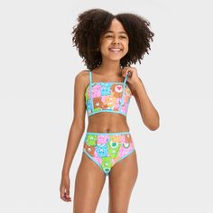 Give their swimwear collection a playful boost with this Care Bears Fictitious Character Bikini Set. This two-piece bikini set includes a bandeau bikini top and a matching hipster swim bottom featuring colorful print of Care Bears characters for a cute look. Designed with a pull-on style, both the pieces are made from stretchy fabric to provide them flexible comfort while diving, swimming or running along the beach, and the UPF 50+ rated material offers added sun protection. Playful Blue Beachwear Swimwear, Playful Blue Swimwear For Vacation, Playful Tankini For Pool, Playful Triangle Top Tankini For Pool, Playful Swimwear For Pool And Beach Season, Beachwear Swimwear With Triangle Top For Play, Fitted Playful Tankini, Playful Tankini With Triangle Top For Pool, Fun Blue Swimwear For Sunbathing