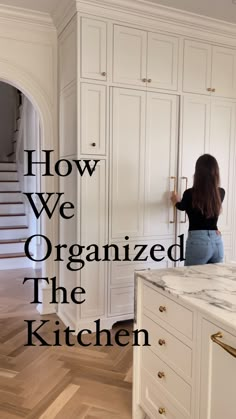 a woman standing in front of a white kitchen with the words how we organized the kitchen