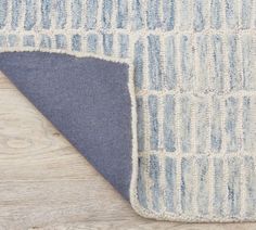 a blue and white area rug on top of a wooden floor next to a piece of wood