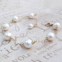 Beautifully polished white cultured pearls create a classic and elegant bracelet for a June born woman since pearl is her traditional birthstone. Genuine natural freshwater pearls are carefully hand wire wrapped with 14k gold filled wire and finished with a gold filled clasp and chain extender for the perfect fit every time.  Give a thoughtful high quality real pearl gift for mom who loves pearls or for your bride who loves dressy classic pearl jewelry. Gorgeous accessory for a little black dres Elegant Pearl Bracelet With Pearl Drop For Anniversary, Akoya Pearl Bracelet With Pearl Charm For Wedding, Wedding Akoya Pearl Bracelet With Pearl Charm, Akoya Pearl Bracelet With Pearl Drop For Wedding, Classic Akoya Pearl Bracelet As A Gift, Akoya Pearl Wedding Bracelet With Pearl Charm, Classic Akoya Pearl Bracelet As Gift, Akoya Pearl Bracelet With Round Beads For Weddings, Classic Akoya Pearl Bracelet Gift