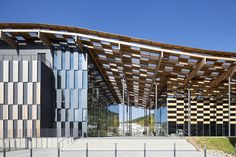 a large building with wooden slats on it's roof and walkway leading up to the entrance