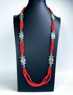 Add color and pizzazz to any outfit with this beautiful hand crafted Tibetan coral color multi strand bead necklace with silver tone amulets. The faux turquoise accents makes the amulets pop! A simple but very striking necklace! Perfect for a beach vacation with a carefree white dress or in the city to dress up jeans. Makes a beautiful gift! Twist the necklace for a totally different look! Excellent quality and craftsmanship. - 3 strands of irregular beads - bright red/orange color - silvertone Bohemian Polished Red Coral Beads, Bohemian Red Coral Polished Beads, Bohemian Red Coral Beads For Jewelry Making, Bohemian Red Coral Beaded Necklace With Polished Beads, Handmade Bohemian Red Coral Beads, Traditional Double Strand Beads For Gift, Traditional Multi-strand Red Coral Necklaces, Traditional Multi-strand Red Coral Beaded Necklace, Handmade Multi-strand Red Coral Necklace