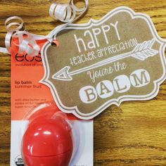 a red ball is sitting on top of a card with a tag that says happy health appreciation you're the balm