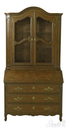 an old fashioned wooden dresser with glass doors