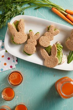 some carrots are sitting on a plate with bunny cookies