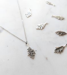 This is a dainty solid sterling silver oak leaf pendant on a hypoallergenic stainless steel fine chain. The detail on this leaf is incredible, with each vein being visible. This necklace can be showered in but I recommend it be taken off during sleeping due to the fine nature of the chain. Many chain lengths available🌲 Thank you so much for checking out my shop!🧡 Silver Leaf-shaped Necklaces For Gift, Silver Leaf-shaped Necklace Gift, Silver Leaf-shaped Necklace For Gift, Sterling Silver Leaf-shaped Jewelry Gift, Nature-inspired Silver Jewelry With Charms, Nickel-free Leaf-shaped Sterling Silver Jewelry, Silver Leaf-shaped Sterling Silver Necklace, Nature-inspired Silver Jewelry With Adjustable Chain, Hypoallergenic Leaf-shaped Jewelry Gift