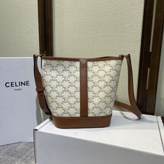 The body pattern of the Celine Small bucket bag is dominated by the Arc de Triomphe buckle logo and is surrounded by brown cowhide to create retro elements. The retro color system is suitable for winter with a coat. It has a large capacity and light weight. Wear-resistant waterproof not easy to scratch. White & Tan. Triomphe logo prints. Canvas & Smooth Calfskin Leather. Fabric Lining. Gold toned hardware. Snap button Closure. Waterproof. Shoulder & Crossbody Carry. Adjusta... Celine Small Bucket Bag, Body Pattern, Retro Elements, Small Bucket Bag, Luxury Clutch, Small Buckets, Brown Cowhide, Hot Bags, Celine Bags