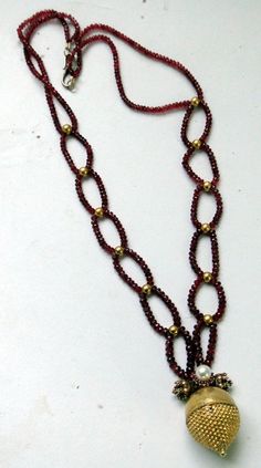 "An exclusive beautiful tribal pendant necklace from Rajasthan northern India. We sourced this piece of gem from a well known tribal family on the outskirts of Jodhpur. Solid well made 22 karat Gold sphere , the bottom half has tiny granulation ending with a tiny ball, the top half is quite shiny finish, set with a natural high grade Burmies Ruby and Pearl ,strung with Micro faceted spinal Ruby and gold beads. Ending with a beautiful golds clasp. Total length-54 cm(21\")we can adjust length, siz Spiritual 22k Gold Necklace With Gemstone, Traditional Hand-strung Round Jewelry, Traditional Yellow Gold Beaded Necklaces, Temple Jewelry With Polished Round Beads, Festive Temple Jewelry Beaded Gemstone Necklaces, Festive Temple Jewelry Style Gemstone Beaded Necklaces, Handmade Yellow Gold Temple Necklace, Kundan Temple Jewelry Necklace With Round Gemstone Beads, Traditional Hand-strung Jewelry