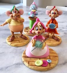 three cartoon figurines sitting on top of a table