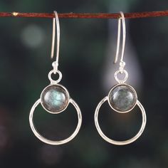 In these fascinating dangle earrings, a gleaming sterling silver loop plays host to a resplendent labradorite gemstone, casting an ethereal luminosity that catches the eye. This precious design by India's Sapna Mehta transcends the ordinary, weaving a narrative of timeless charm that dances with your every move. Add a touch of glamor and elegance to your look with these lustrous and alluring earrings. Wood Dangle Earrings, Labradorite Earrings, Sterling Silver Brooch, Labradorite Jewelry, Beaded Pendant Necklace, Silver Dangle Earrings, Silver Brooch, Labradorite Stone, Silver Earrings Dangle