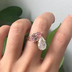 a woman's hand with two pear shaped diamonds on it