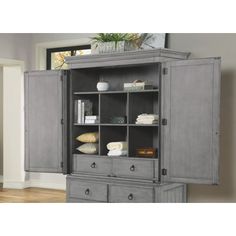 an armoire with two doors and drawers in grey finish, next to a wooden floor