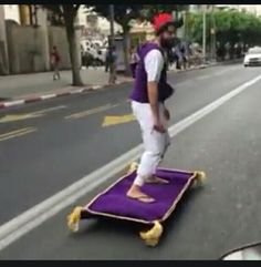 a man riding on top of a purple skateboard