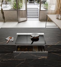 a stove top sitting on top of a counter next to a door and window sill