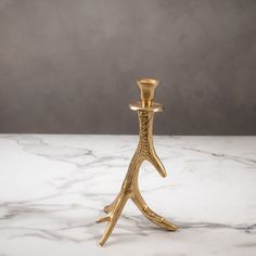 a gold candle holder on a marble table