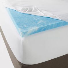 a close up view of a mattress with blue and white sheets on it's side