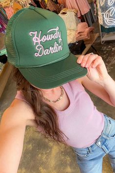 Get ready to add a pop of color to your summer look with the Howdy Darlin' Pink & Green Embroidered Trucker Hat ! This green trucker hat features a mesh back, snapback closure, and a vibrant pink "Howdy Darlin'" embroidery. It's perfect for those sunny days at the lake or beach, allowing you to stay cool and stylish while protecting your face from the sun. Add a touch of fun and personality to your outfit with this trendy and eye-catching trucker hat!   Features:   Green trucker hat with a mesh back for breathability.  Snapback closure for an adjustable and comfortable fit.  Vibrant pink "Howdy Darlin'" embroidery adds a fun and playful touch.  Perfect accessory for summer lake or beach days.  Provides shade and protection from the sun while keeping you stylish. Cheap Embroidered Baseball Cap Trucker Hat, Cheap Pink Trucker Hat For Beach, Affordable Trucker Hat With Letter Embroidery, Green Trucker Hat, Summer Lake, Green Hats, At The Lake, Summer Look, Trendy Accessories