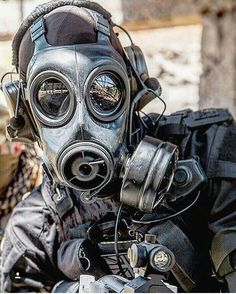 a man wearing a gas mask sitting on a motorcycle