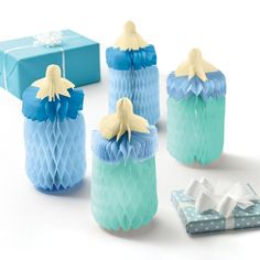 four blue and white honeycombs with bows on them next to some gift boxes