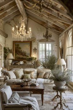 a living room filled with furniture and a chandelier hanging from the rafters