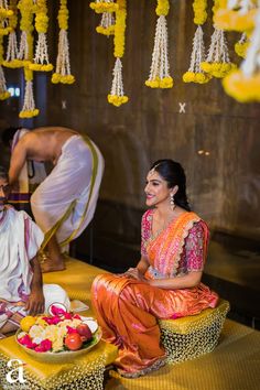 a man and woman sitting on the ground with food in front of them at a wedding