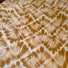 an image of a bed that is made with brown and white flowers on the sheets