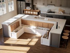 an overhead view of a kitchen with white counter tops and wooden flooring in the middle