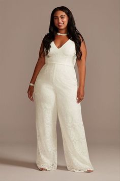 a woman in a white jumpsuit posing for the camera with her hands on her hips