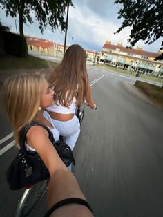 two girls riding on the back of a motorcycle