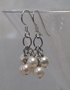 Good quality white fresh water pearl clusters are featured in these pierced earrings. All metal is 925 sterling silver. Each earring weighs 2.1 grams compared to a US dime weighing 2.268 grams. Size and length can be determined in the photo above as compared to a US dime and a ruler. For questions and or requests feel free to contact me. These earrings are ready to ship free via USPS Priority Mail with insurance. Thank You for looking. White Pearl Drop Dangle Cluster Earrings, White Pearl Drop Cluster Earrings, Silver Pearl Cluster Earrings For Anniversary, White Pearl Drop Cluster Earrings For Anniversary, White Sterling Silver Drop Cluster Earrings, Silver Cluster Earrings With Pearl Drop For Gift, Silver Pearl Cluster Earrings For Formal Occasions, Formal Silver Cluster Earrings With Pearls, Formal Silver Pearl Cluster Earrings