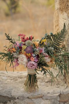 a bouquet of flowers sitting on top of a stone wall