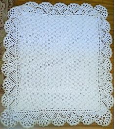 a white crocheted doily on a wooden table