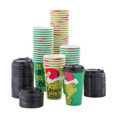 the grinch squad cups are stacked on top of each other and have santa's hats on them